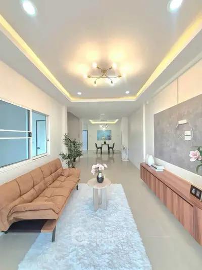 Spacious modern living room with elegant lighting and cozy seating area, perfect for relaxation and entertainment.