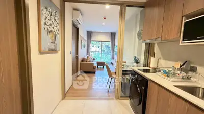 Modern apartment interior with open kitchen and cozy living room, featuring stylish decor and natural light.