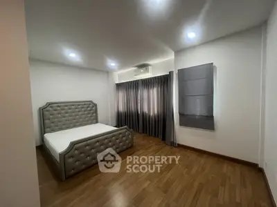 Spacious bedroom with elegant bed and wooden flooring in modern apartment