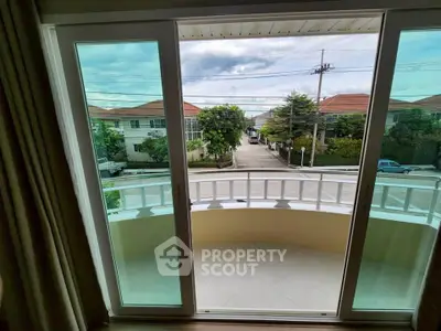 Charming balcony view with sliding glass doors overlooking suburban street.