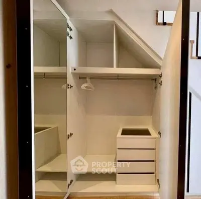 Spacious walk-in closet with mirrored doors and ample storage space.