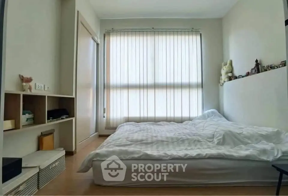 Cozy bedroom with large window and minimalist decor, perfect for relaxation and comfort.