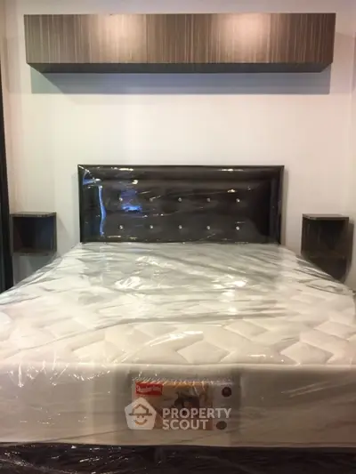 Modern bedroom with stylish headboard and new mattress in sleek apartment.