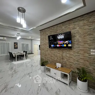 Spacious modern living room with elegant decor and wall-mounted TV, perfect for family gatherings.