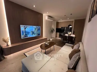 Modern living room with open kitchen, stylish decor, and cozy seating area.
