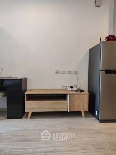 Modern kitchen with sleek fridge and minimalist wooden cabinet
