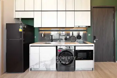 Modern kitchen with sleek appliances and stylish cabinetry in a contemporary apartment.