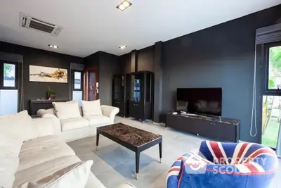 Stylish modern living room with plush sofas and large TV, perfect for relaxation.