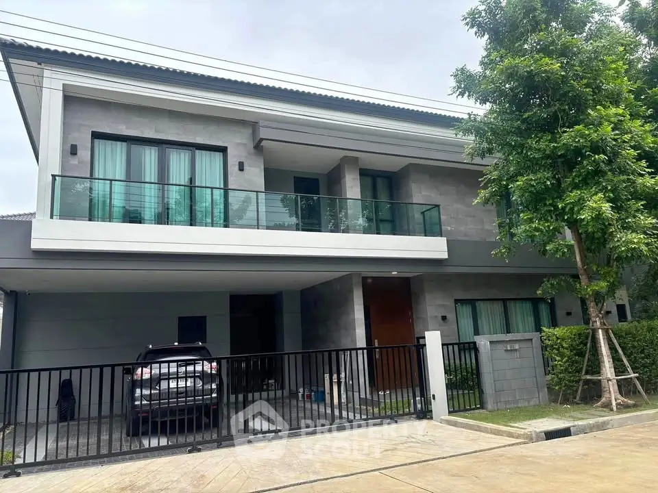 Modern two-story house with spacious balcony and garage in a serene neighborhood.
