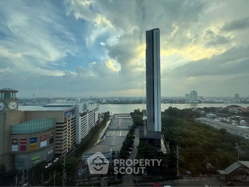 Stunning cityscape view with modern high-rise building and river backdrop at sunset.