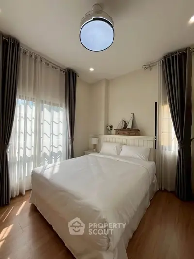 Cozy bedroom with elegant curtains and soft lighting, perfect for relaxation and comfort.