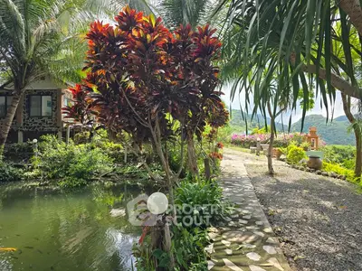 Lush garden with pond and scenic mountain view, perfect for tranquil living.