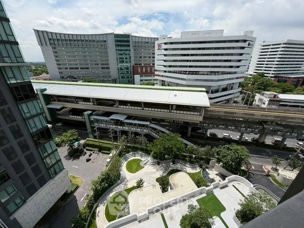 Stunning urban view from high-rise apartment overlooking modern cityscape and lush green spaces.