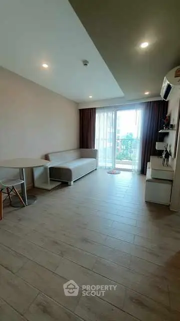 Modern living room with sleek furniture and natural light from large windows.