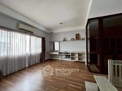 Spacious living room with wooden flooring and large windows