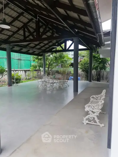 Spacious covered patio with elegant outdoor seating and lush garden view