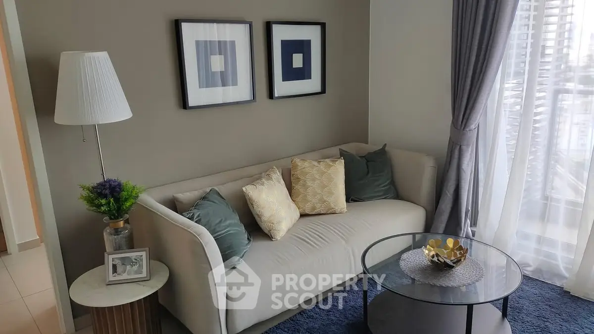 Modern living room with cozy sofa, stylish decor, and large window view.