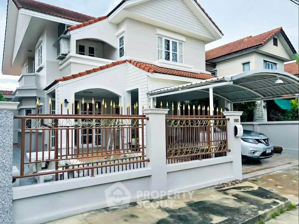Charming two-story house with carport and decorative fencing in a suburban neighborhood.