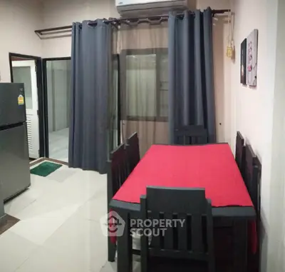 Cozy dining area with modern table and chairs, adjacent to a sleek kitchen and large window.