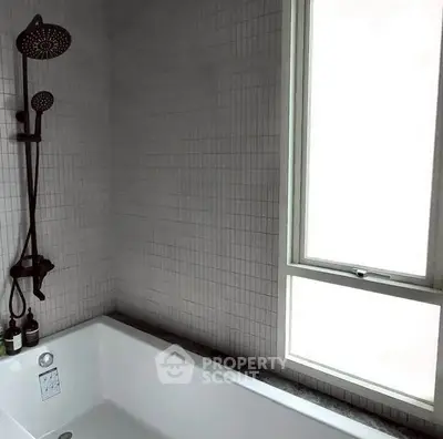Modern bathroom with sleek bathtub and large window for natural light.