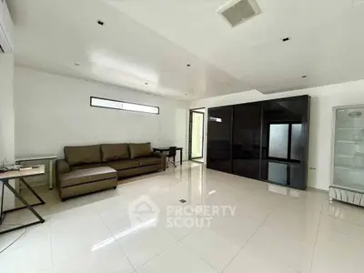 Spacious modern living room with sleek black storage and minimalist design.