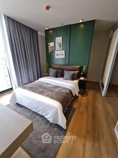 Luxurious bedroom with modern decor and large window offering city views.