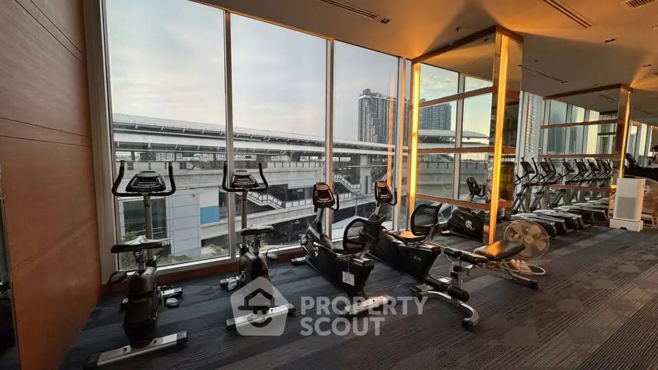 Modern gym with city view and state-of-the-art exercise equipment in a high-rise building.