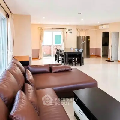 Spacious living room with modern furniture and open dining area, perfect for family gatherings.