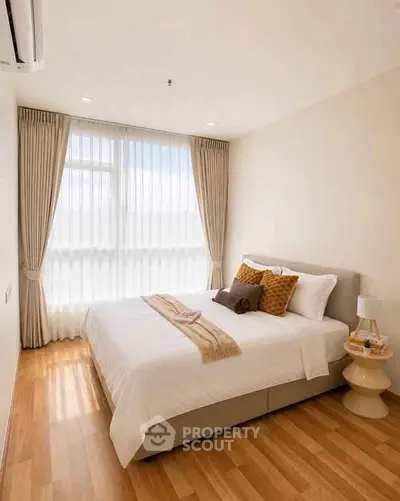 Cozy bedroom with elegant decor and natural light, featuring a comfortable bed and stylish curtains.