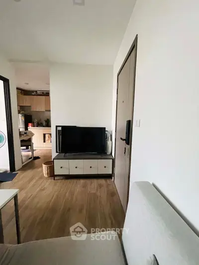 Cozy living room with modern TV setup and wooden flooring