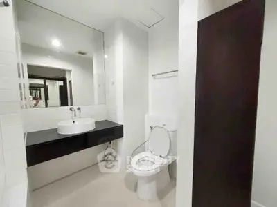 Modern bathroom with sleek fixtures and large mirror in contemporary home.