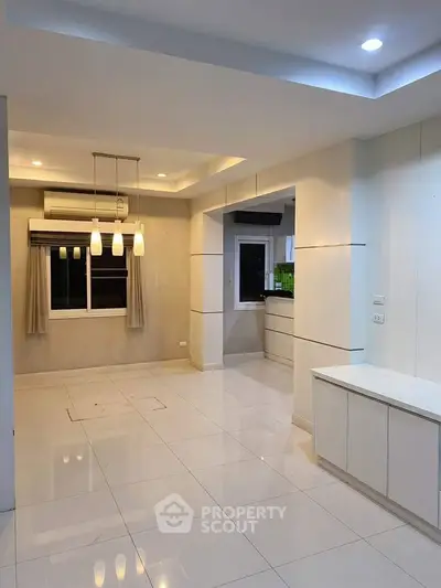 Modern open-layout living room with sleek lighting and tiled flooring
