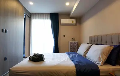 Cozy bedroom with modern decor and natural light, featuring a comfortable bed and air conditioning.