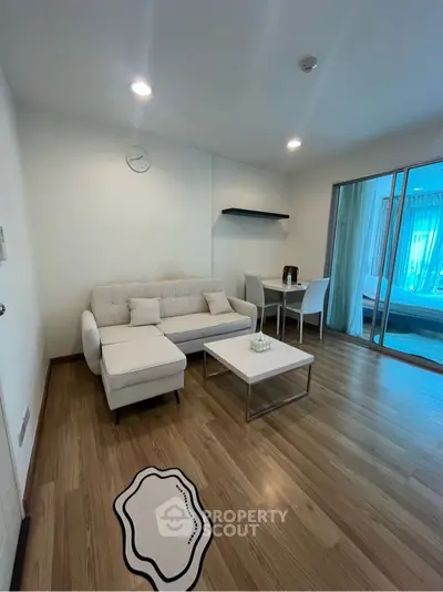 Modern living room with white sofa and dining area in open layout apartment.