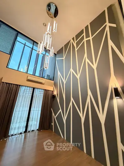 Stunning modern living room with high ceilings and unique geometric wall design