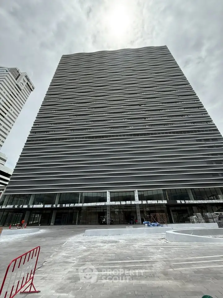 Modern high-rise building with sleek architectural design and expansive glass facade in urban setting.