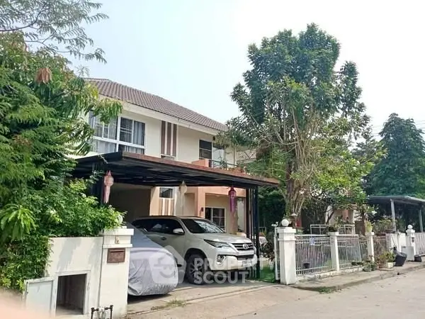 Charming suburban house with carport and lush greenery in a peaceful neighborhood.