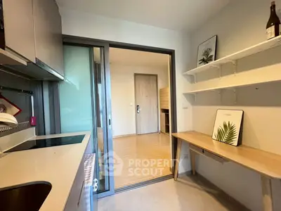 Modern kitchen with sleek design and open layout, featuring built-in appliances and stylish shelving.