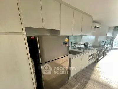 Modern kitchen with sleek cabinets and stainless steel fridge in bright apartment