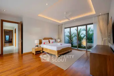Luxurious bedroom with wooden flooring and garden view in modern home