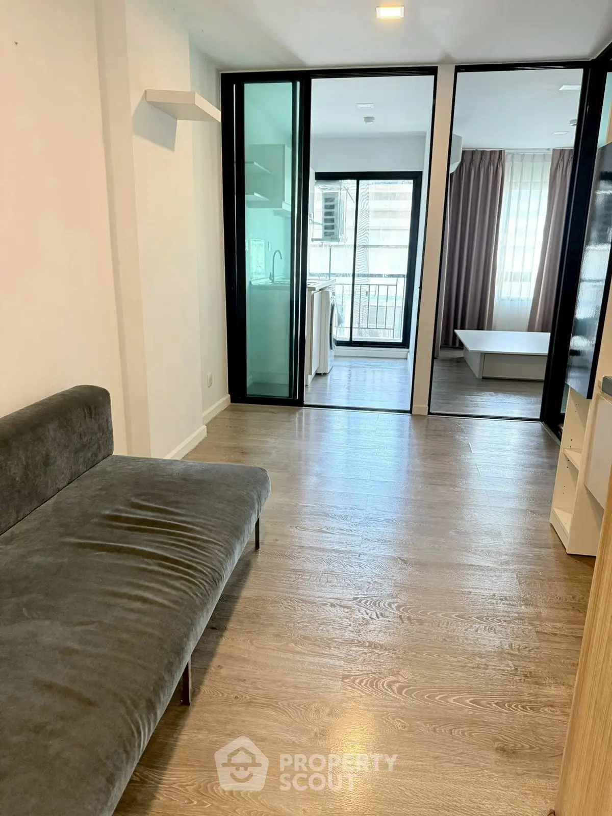 Modern apartment interior with sleek design and spacious layout, featuring a cozy living area and large windows.