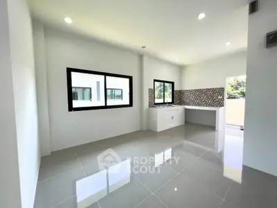 Spacious modern kitchen with sleek tiled flooring and large windows
