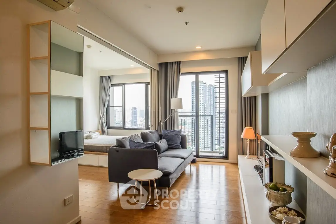 Modern living room with city view, featuring sleek furniture and natural light.