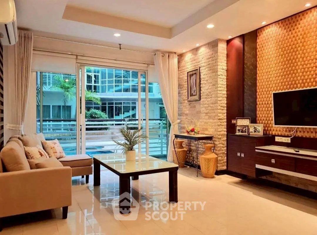 Spacious modern living room with elegant decor and large windows overlooking a balcony.