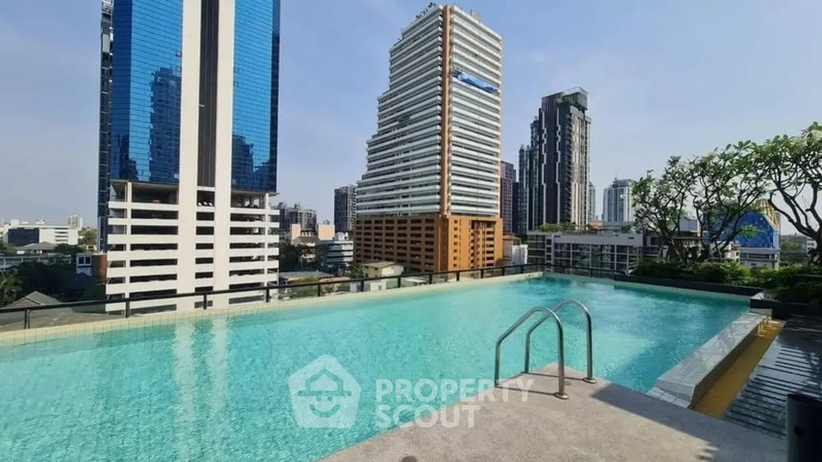 Luxurious rooftop pool with stunning city skyline views in modern urban setting.