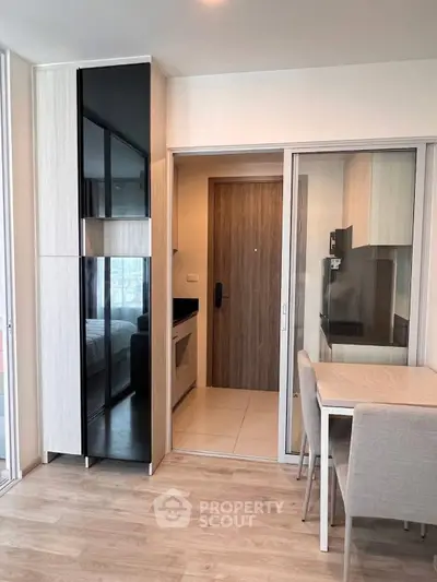 Modern apartment interior with sleek kitchen and dining area, featuring stylish cabinetry and contemporary design.