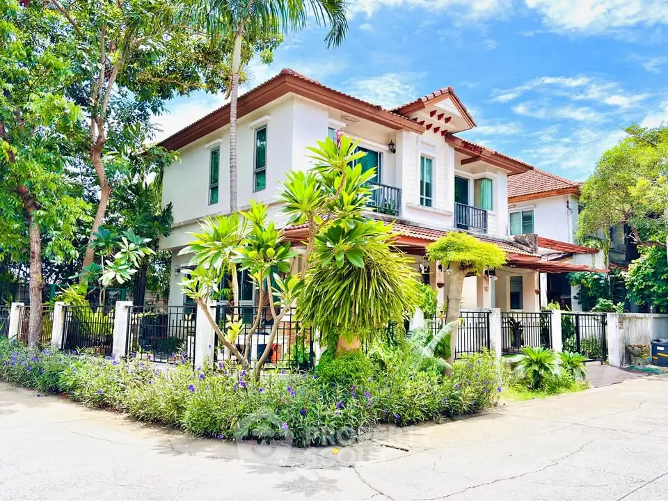 Charming two-story house with lush garden and elegant balcony in serene neighborhood.