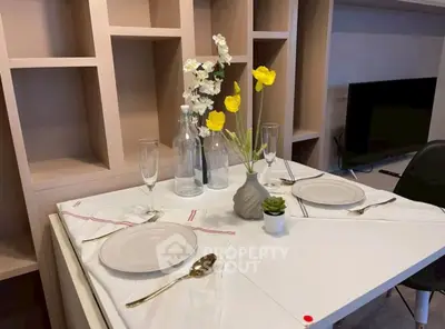 Elegant dining setup in modern living room with stylish shelving and TV unit.