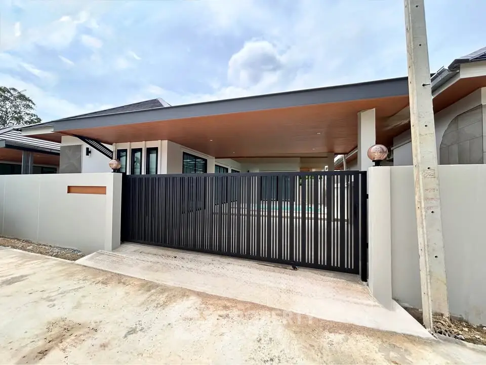Modern single-story house with sleek black gate and spacious driveway