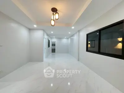 Spacious modern living room with elegant lighting and glossy white flooring